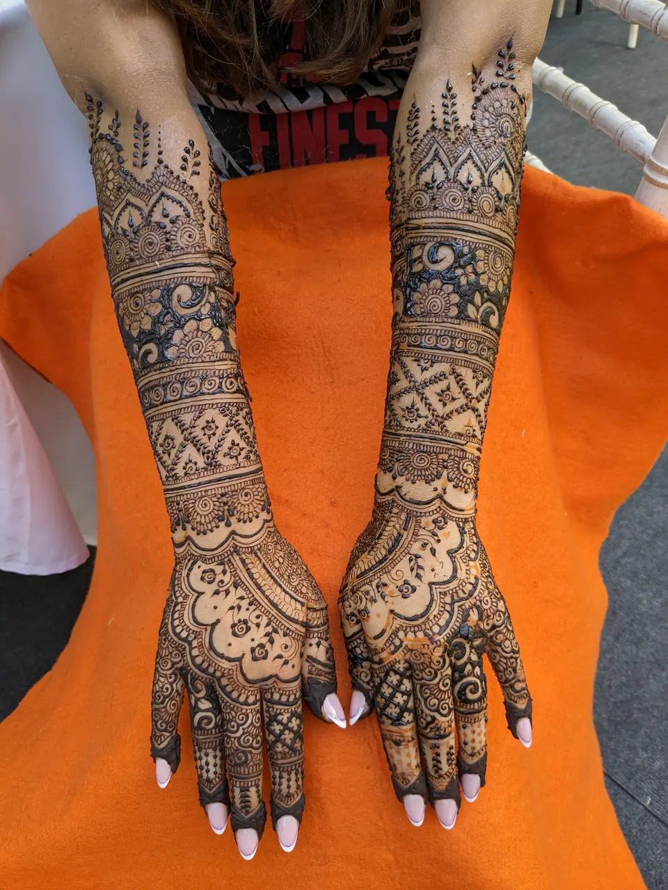 Intricate full-arm bridal henna with lattice and floral bands