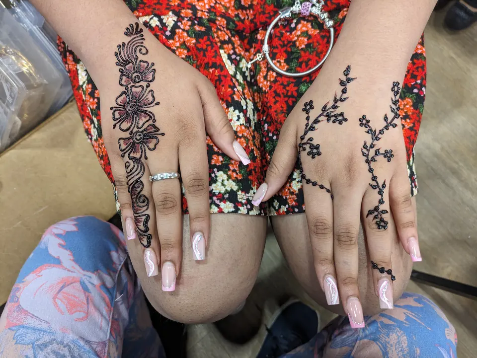 Bold floral Arabic henna trails on the back of the hands