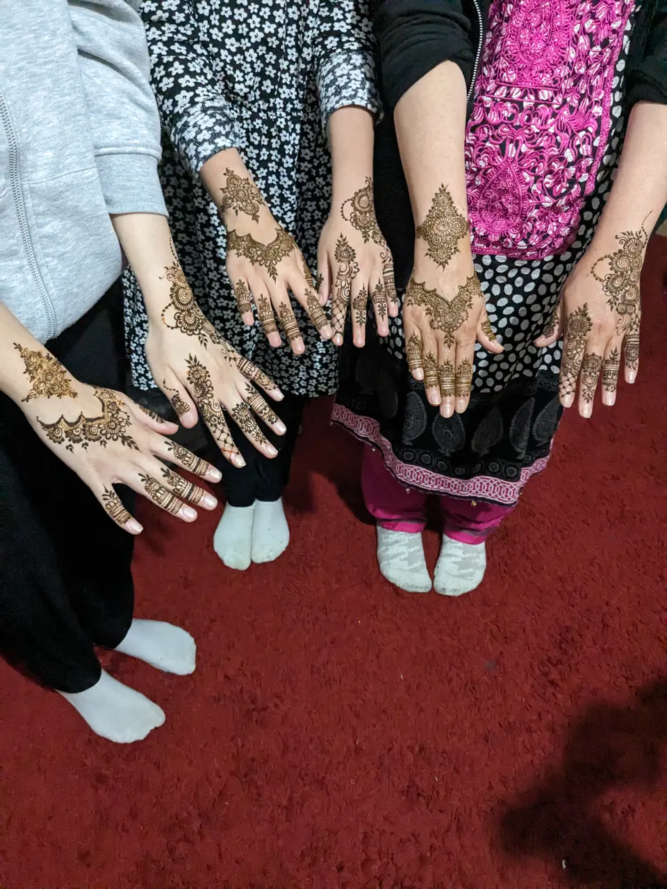 Friends showing off their party henna