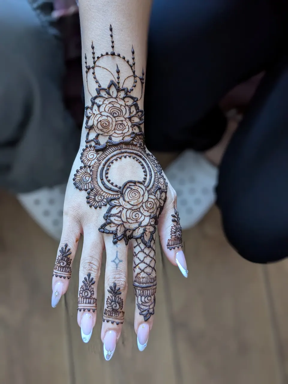 Rose and jaali henna on the back of the hand